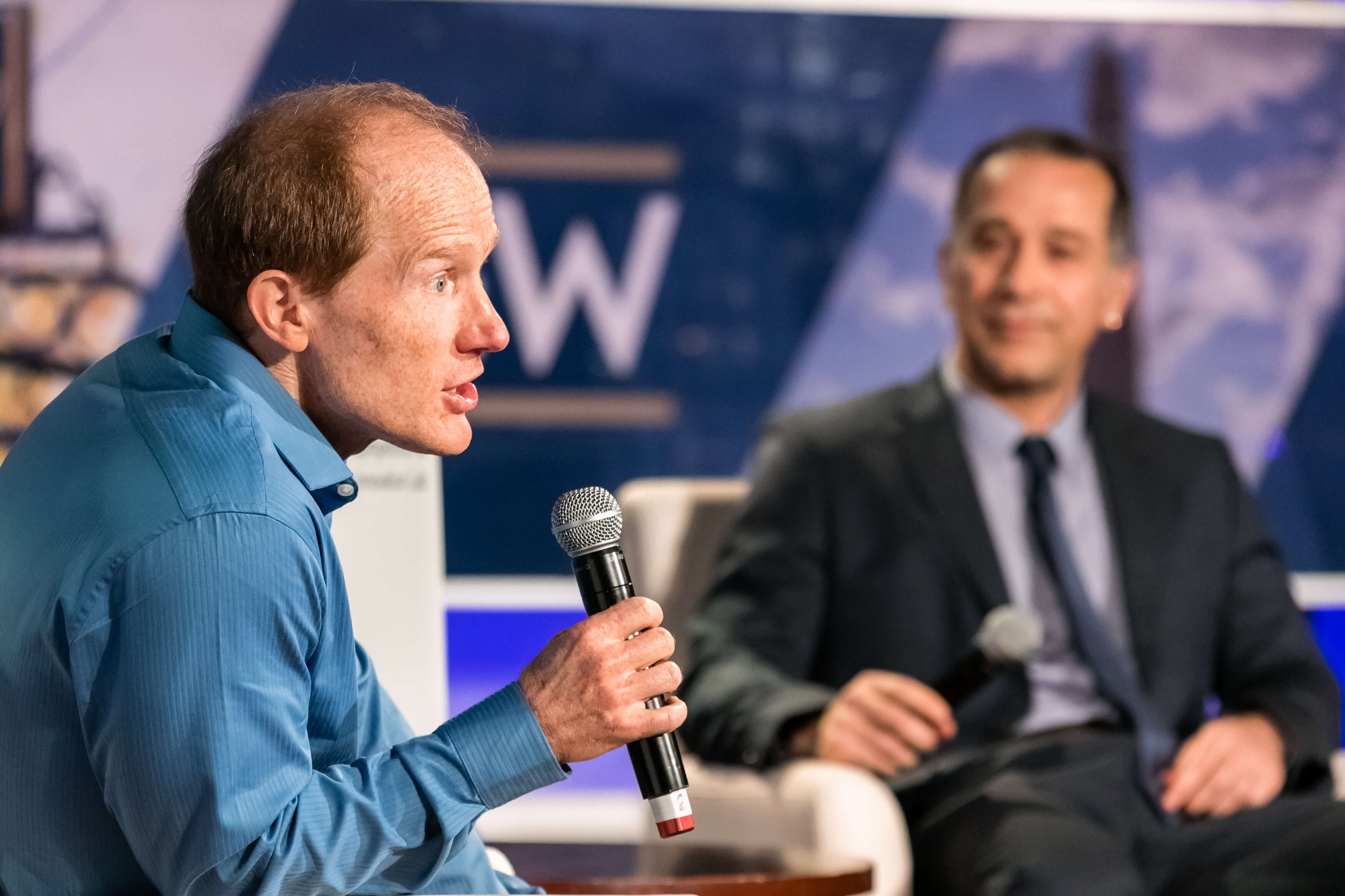 Aurelien Portuese speaks on stage with FTC commissioner, Mark Meador