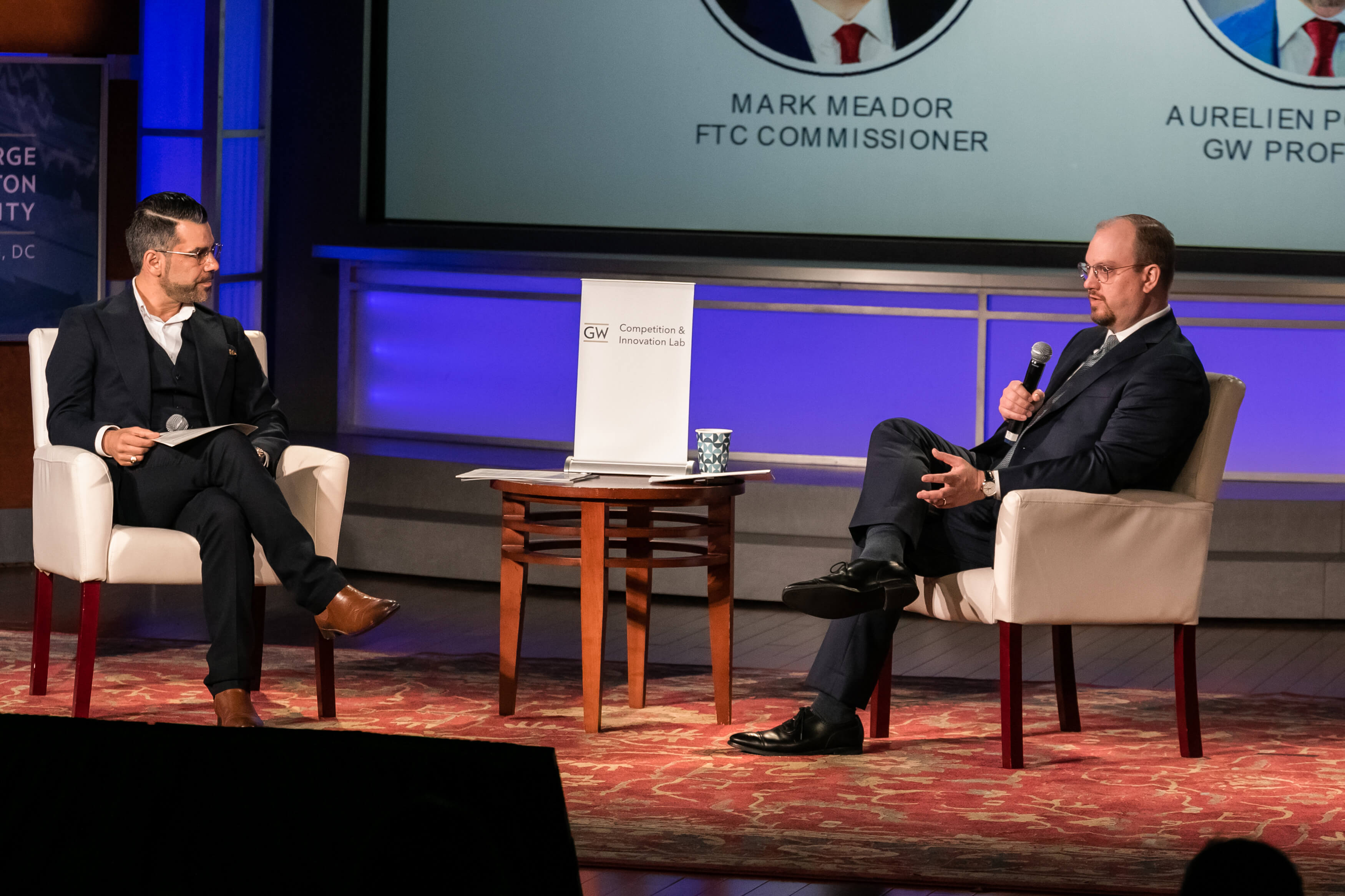 Aurelien Portuese speaks on stage with FTC commissioner, Mark Meador