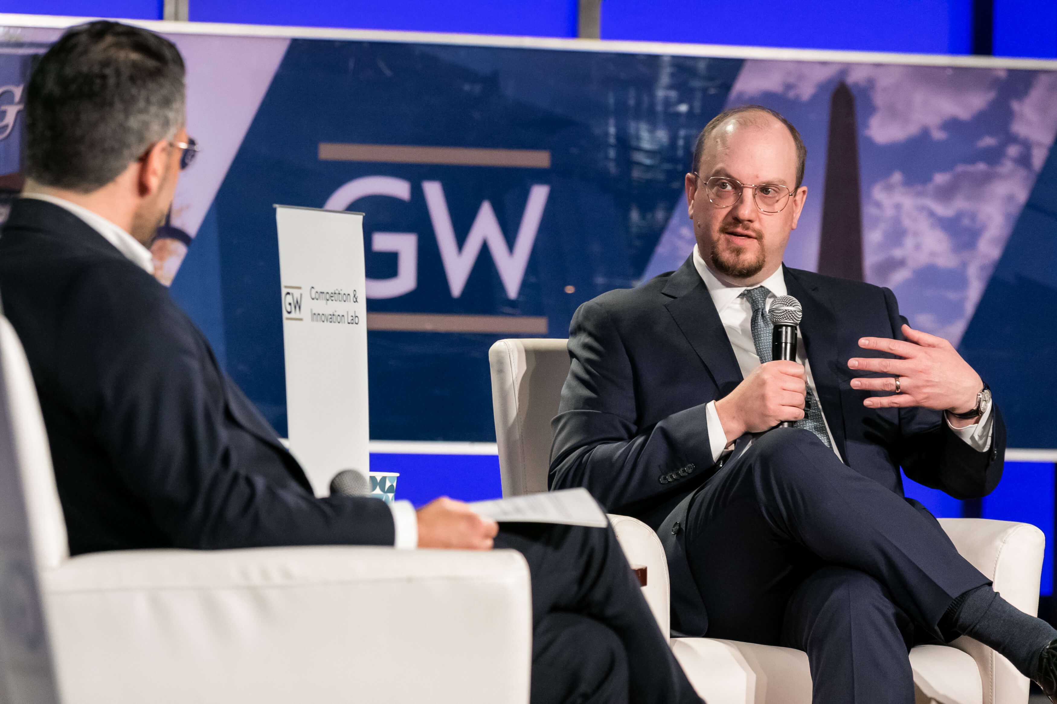 Aurelien Portuese speaks on stage with FTC commissioner, Mark Meador