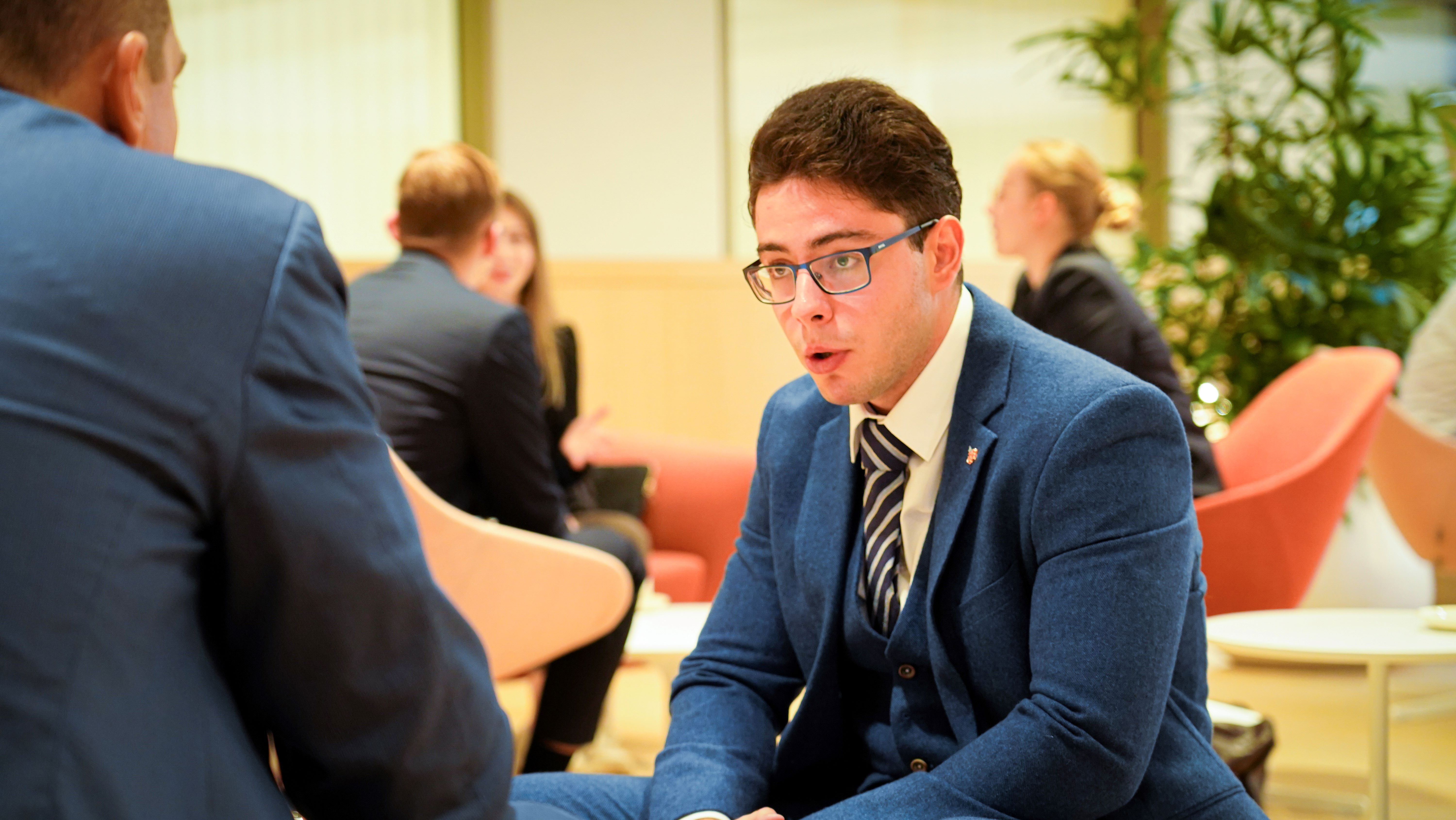 two men in suits having a conversation at a conference