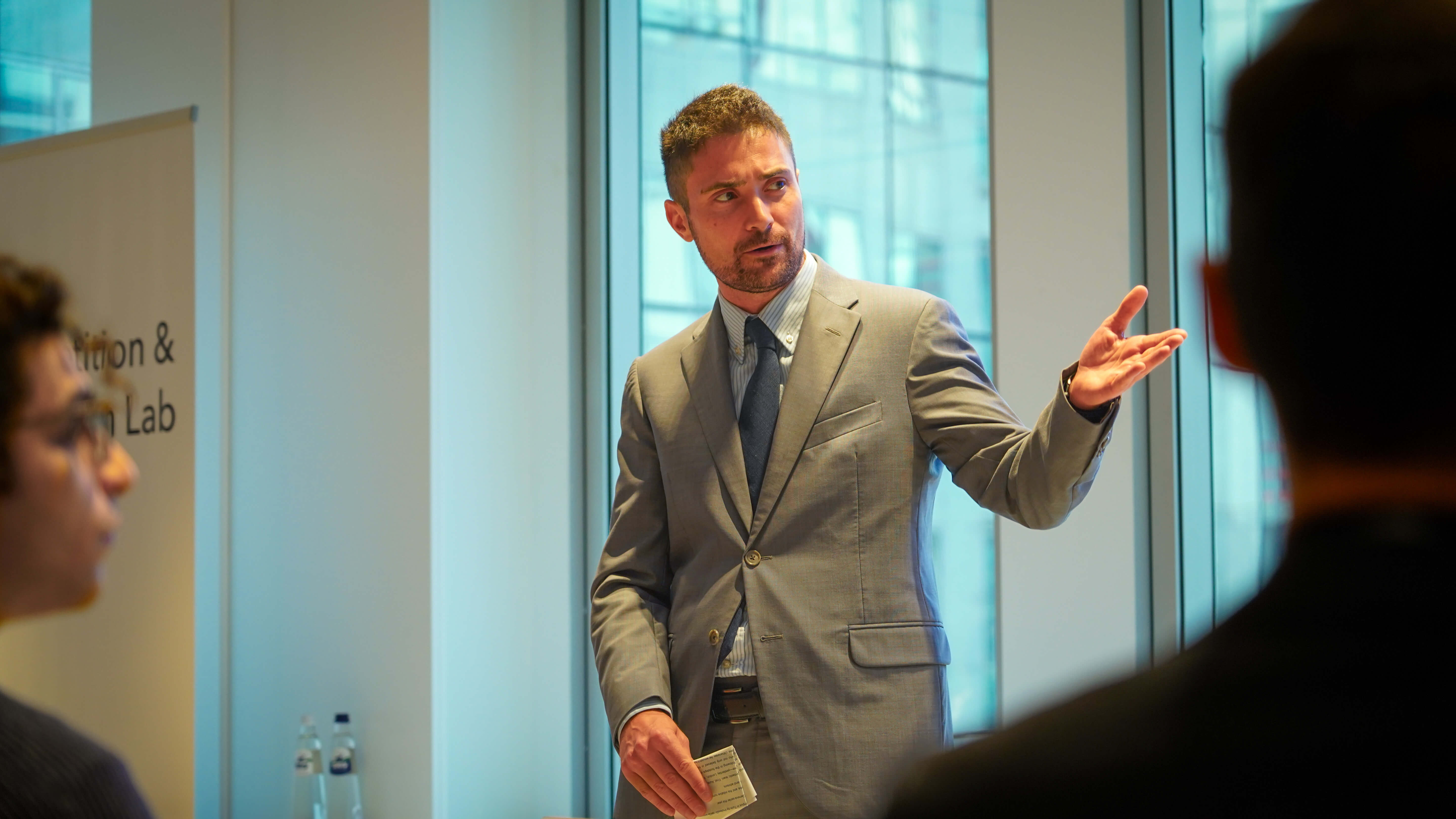 a man in a suit presenting at a conference