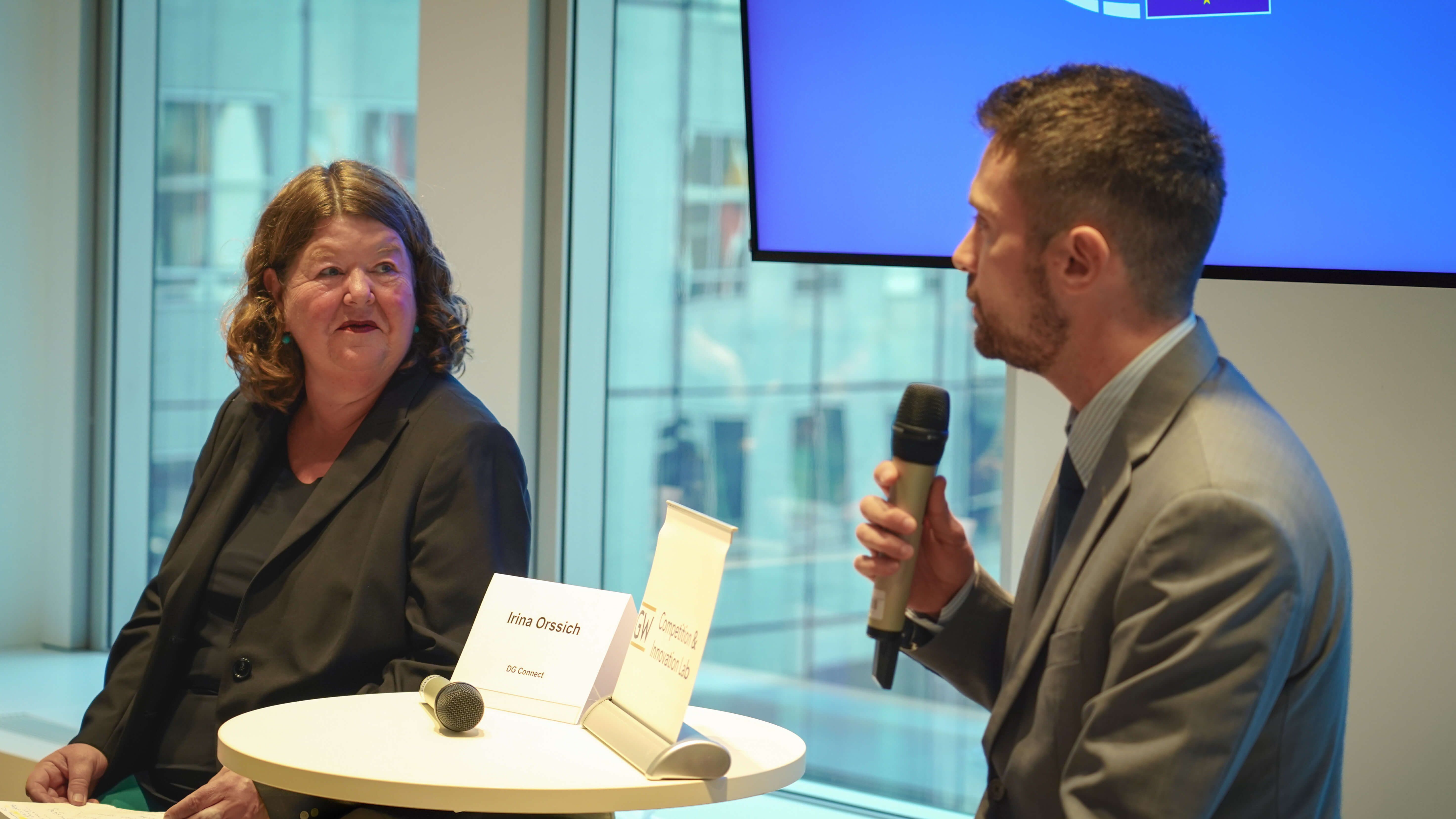 a man and a woman in business wear presenting at a conference
