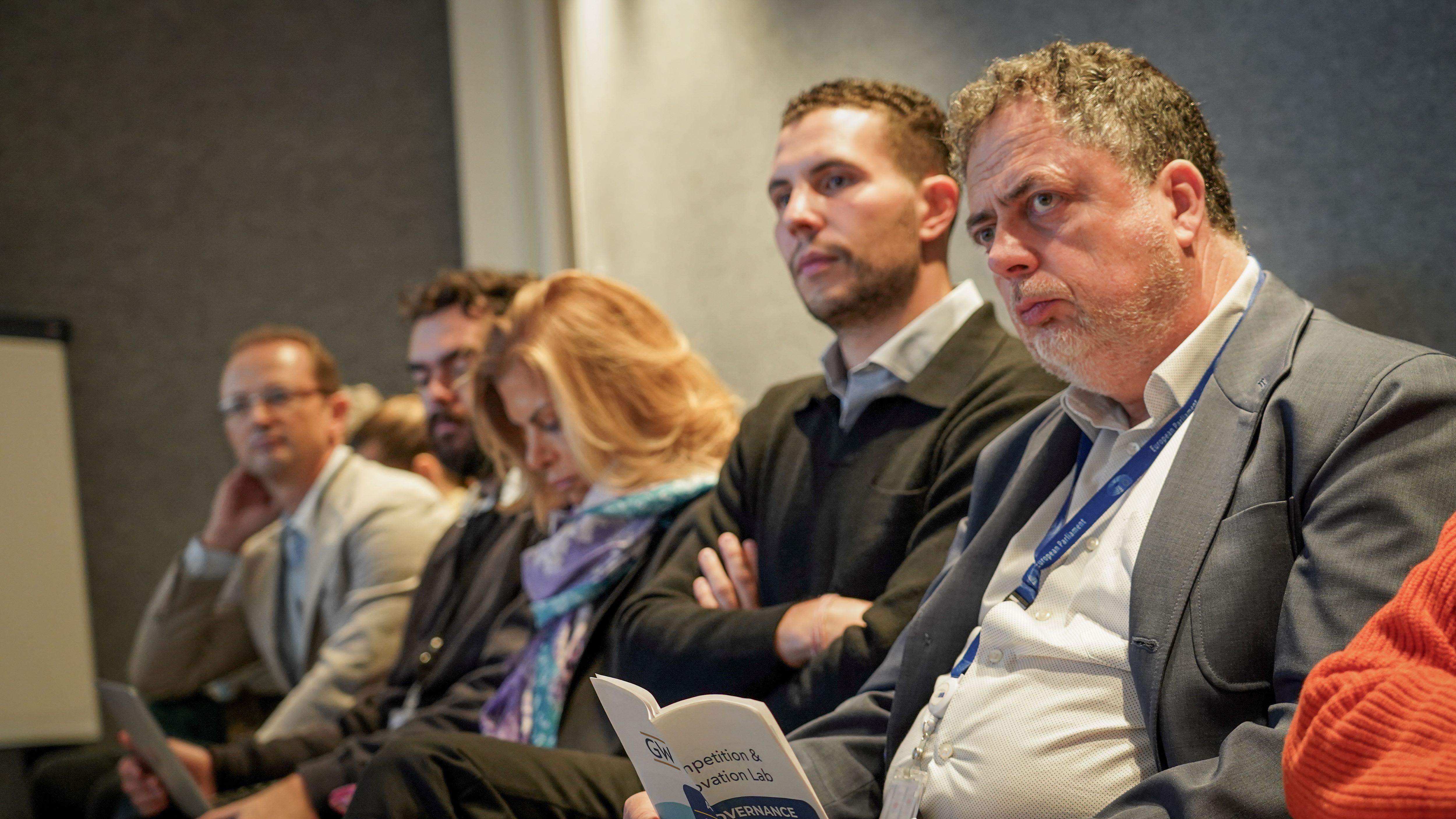a crowd of people in business wear watches a conference presentation