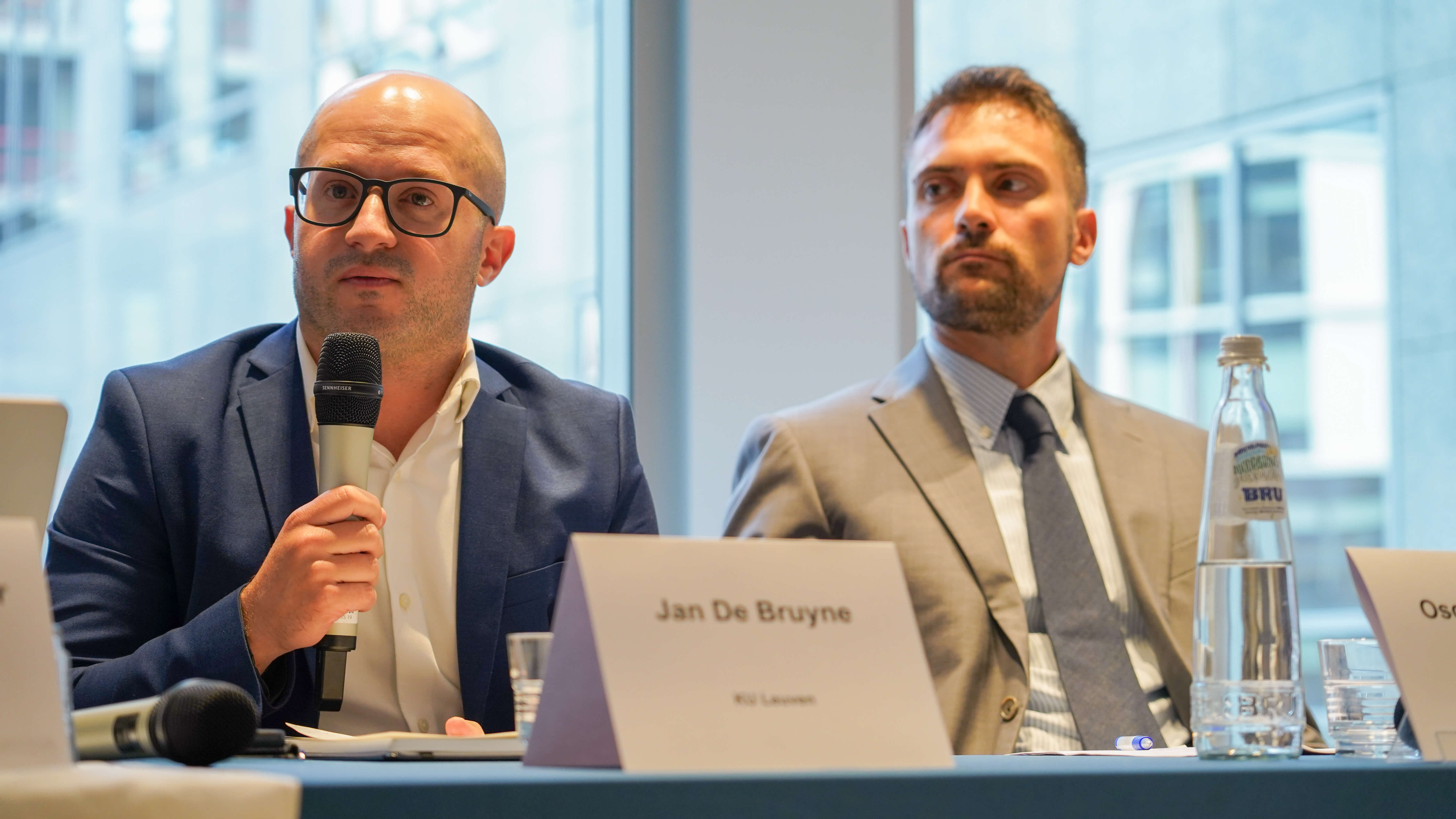 2 men giving a conference presentation on a panel