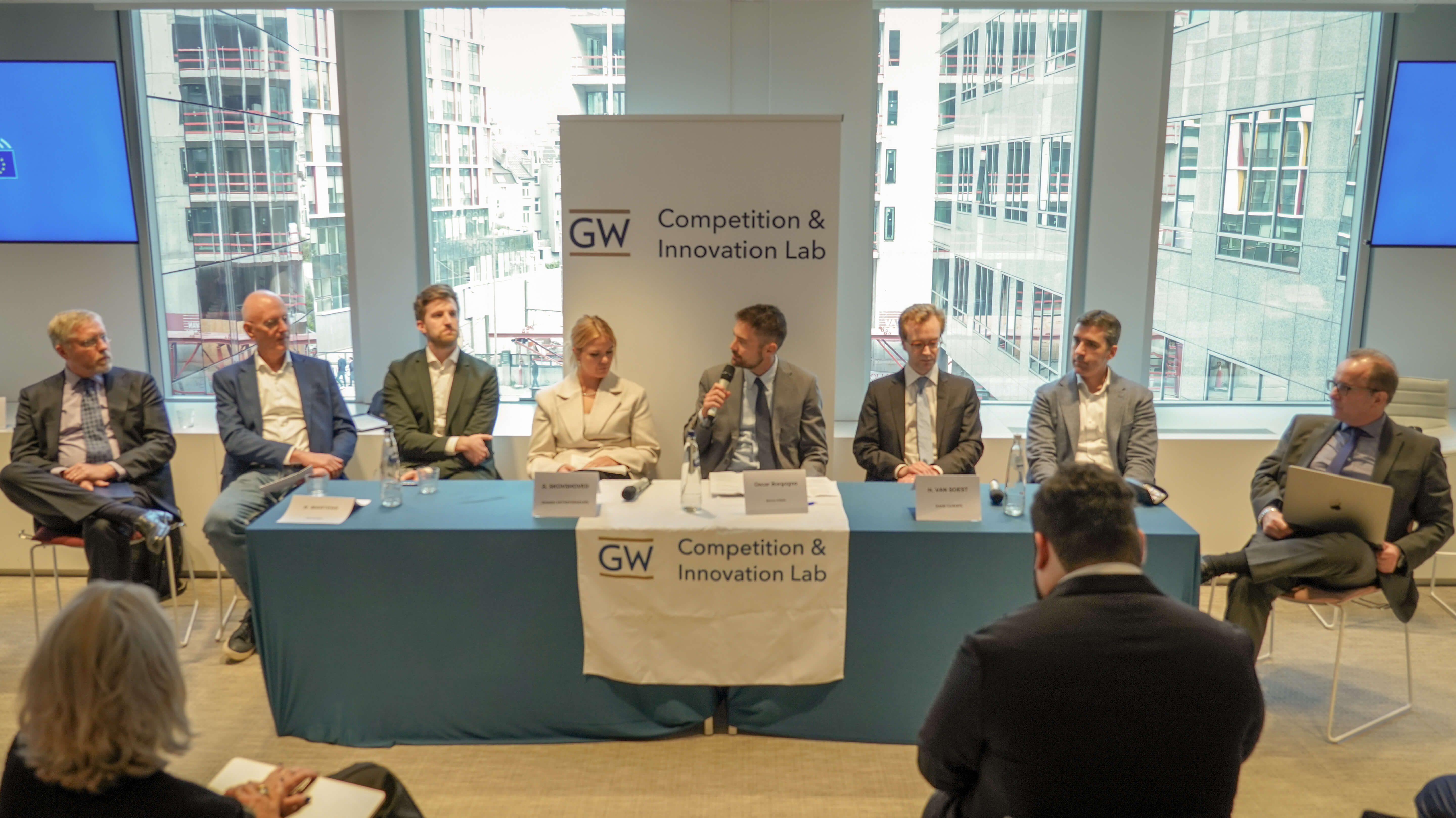 a conference panel consisting of 8 people in business wear