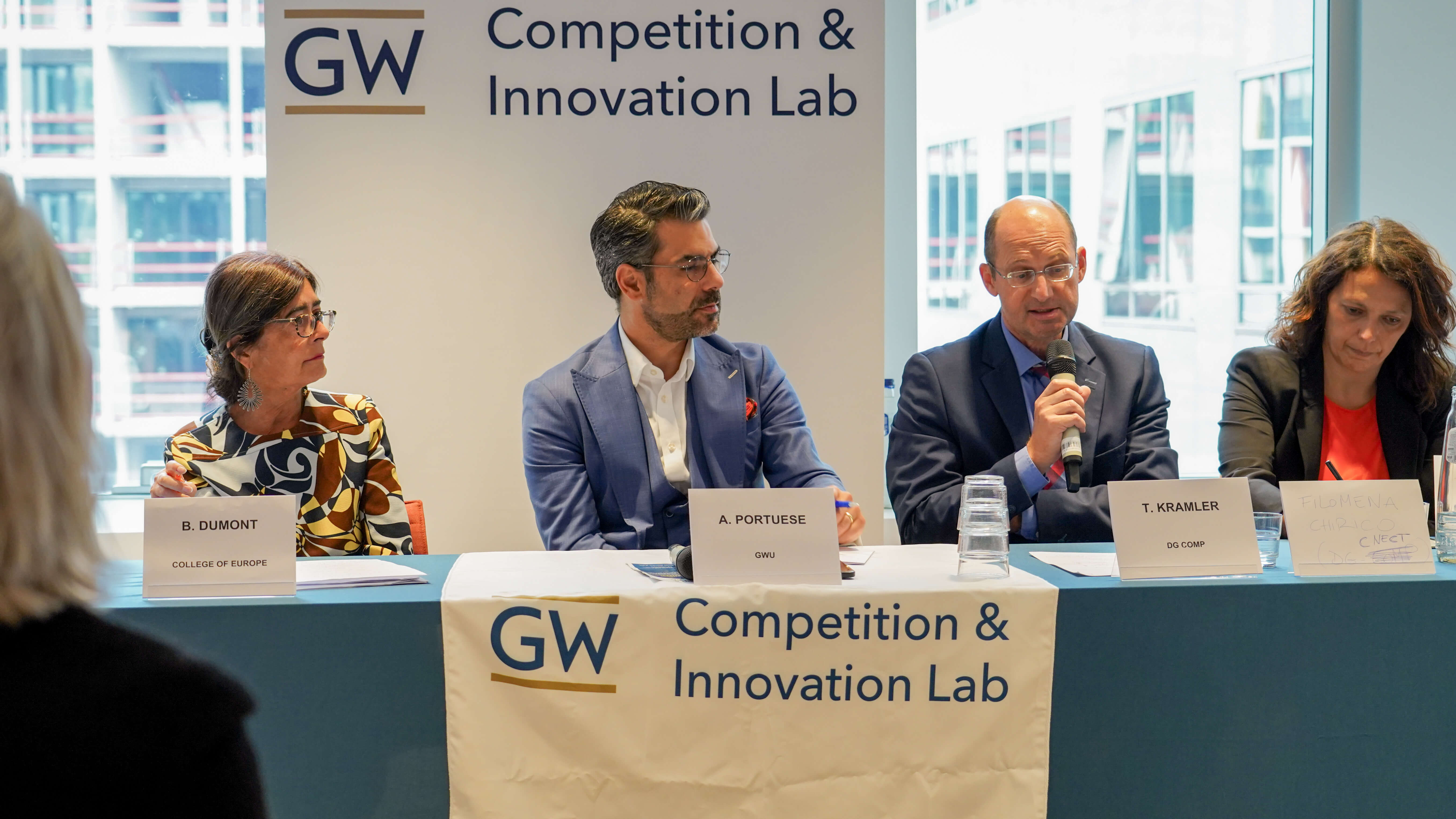 two men and two women in business wear on a conference panel