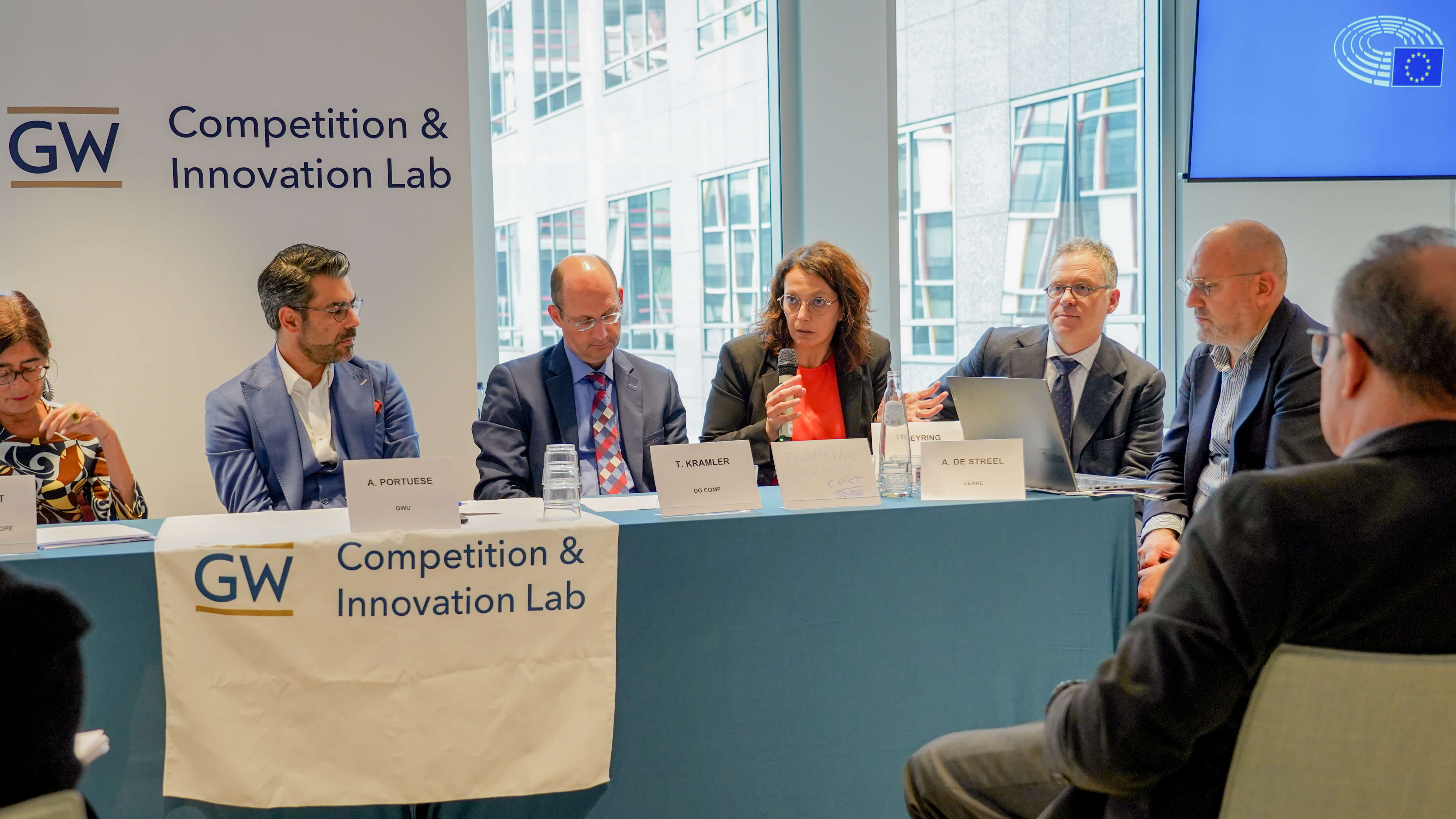 a panel of people in business wear presents at a conference