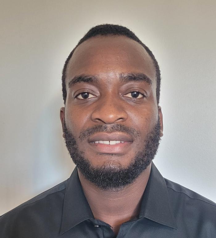 Headshot of Thabani Shumba wearing a button-up black shirt