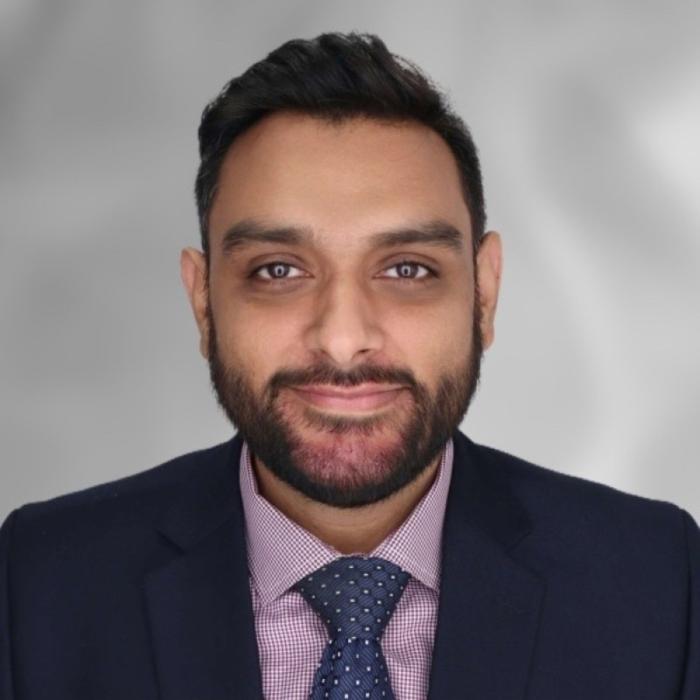 Headshot of Hesham Mushtaq wearing a suit