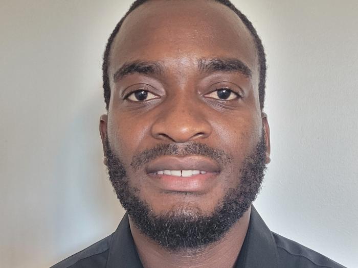 Headshot of Thabani Shumba wearing a button-up black shirt