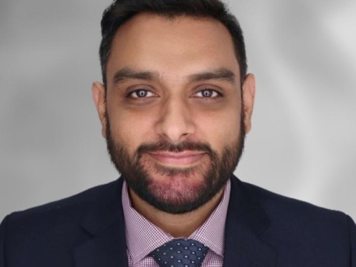 Headshot of Hesham Mushtaq wearing a suit