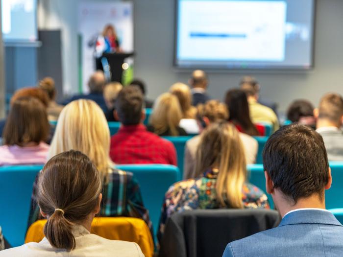 A crowd of people attending an academic workshop, watching someone speak 
