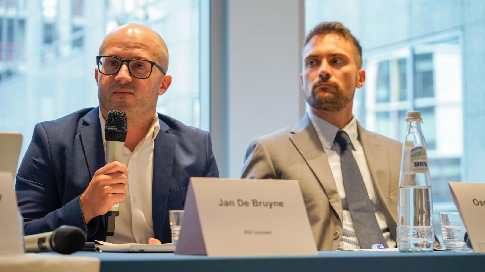 2 men giving a conference presentation on a panel